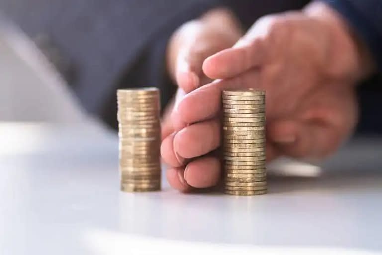 Hand separating stacks of coins evenly