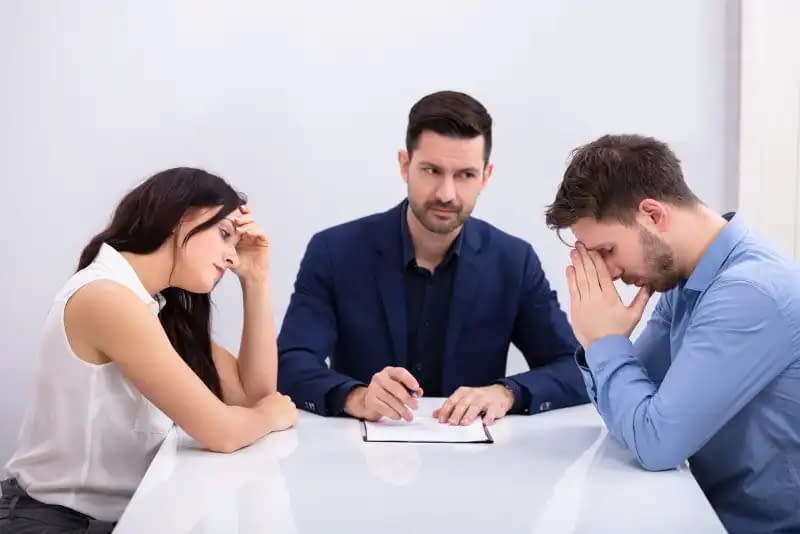 Depressed couple sitting front of mediator